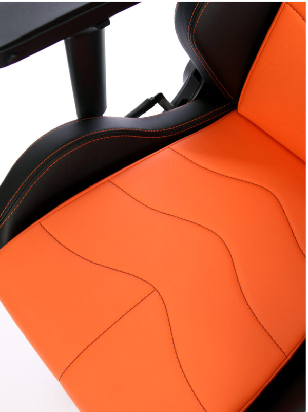 Sitzfläche des Maxnomic® Dominator Orange mit orangefarbenen Nähten bei den schwarzen Akzenten und schwarzen Nähten auf den orangefarbenen Bereichen.