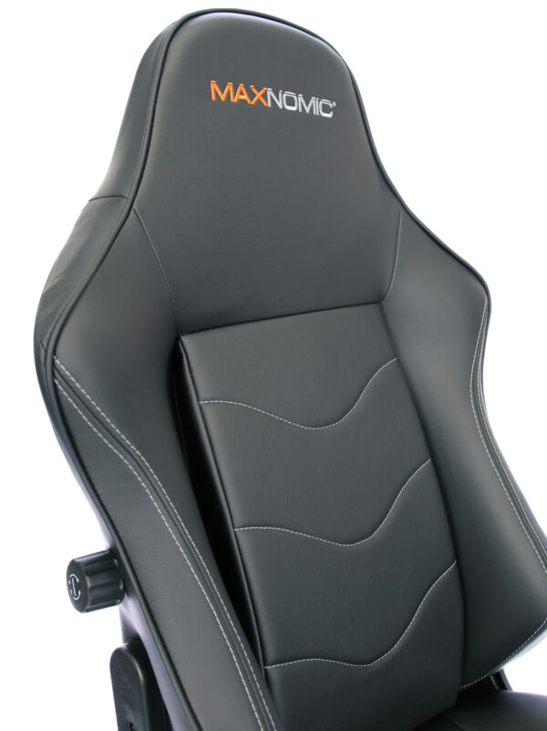 Close-up of the backrest of the Maxnomic® Leader Black with orange/grey embroidered Maxnomic® logo.