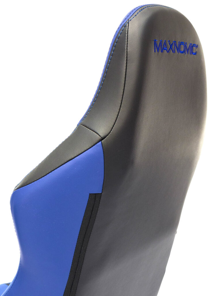 Nahaufnahme des oberen Bereichs der Rückenlehne des Maxnomic® Leader Executive Edition Blau von hinten, mit blauen aufgesticktem Maxnomic®-Logo.