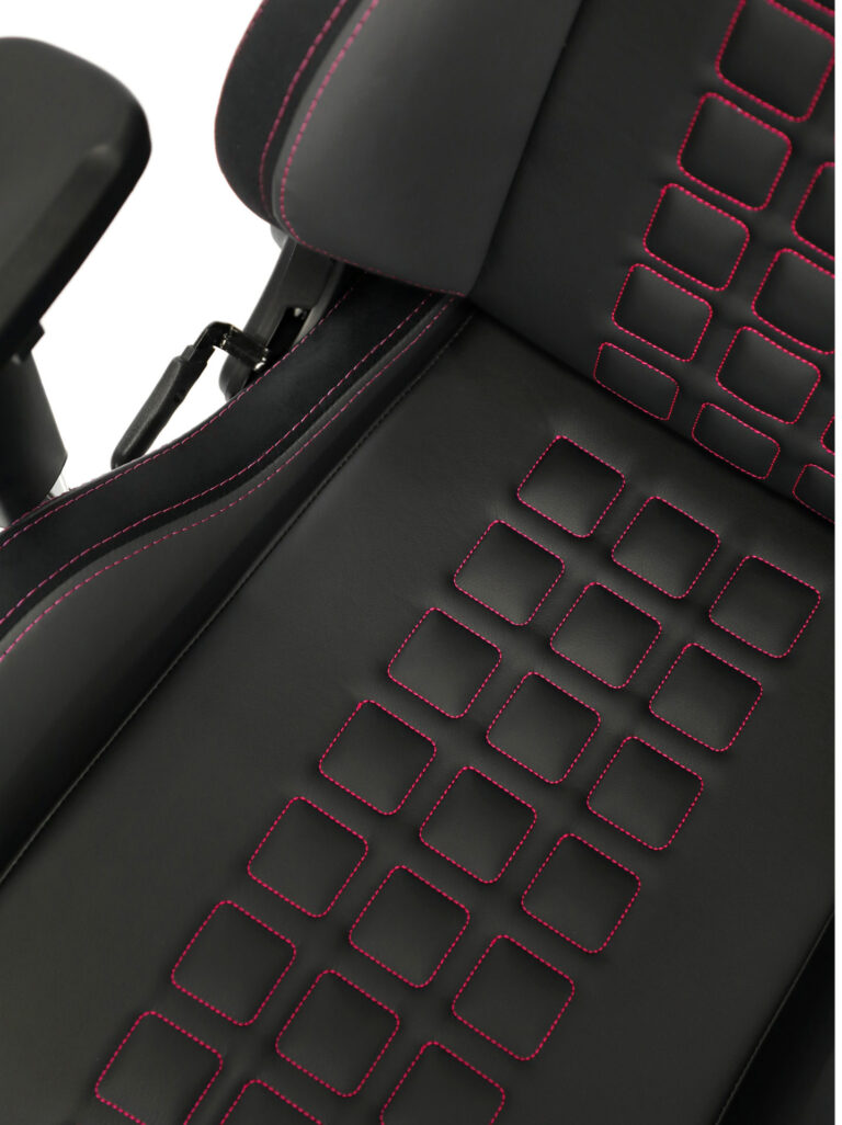 Seat of the Maxnomic® QUADCEPTOR PRO Rasberry Red with red stitching and square topstitching, also with red stitching.